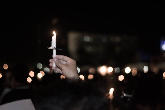 Hand die Erinnerungskerze hält vor einem unscharfen Hintergrund mit Lichtern | Bestattungsvorsorge Bornheim